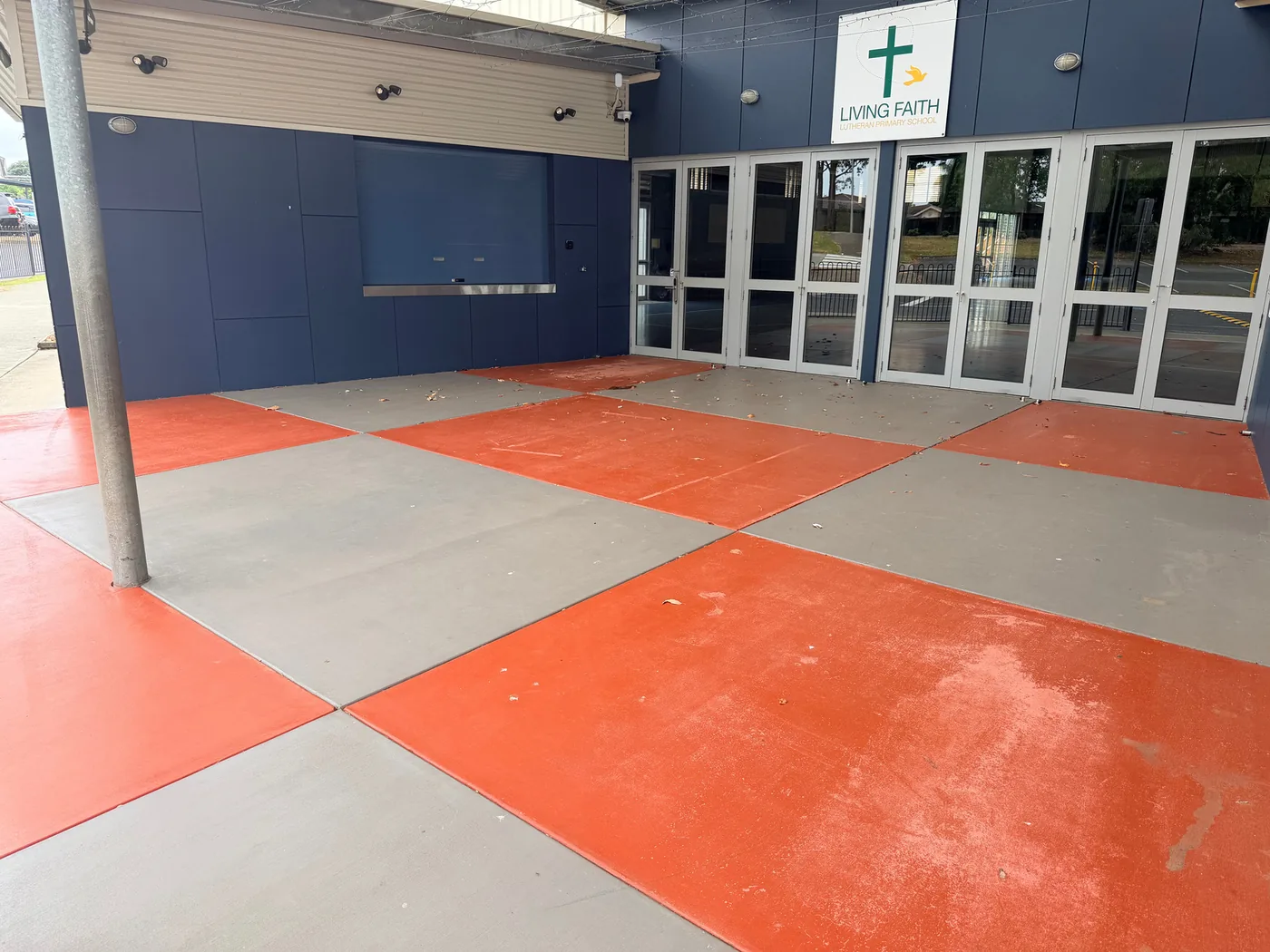 Worn orange and grey chequered entrance before anti-slip resurfacing