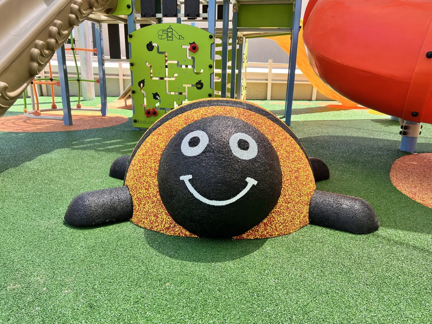 Smiling ladybird softfall playground character in a school play area