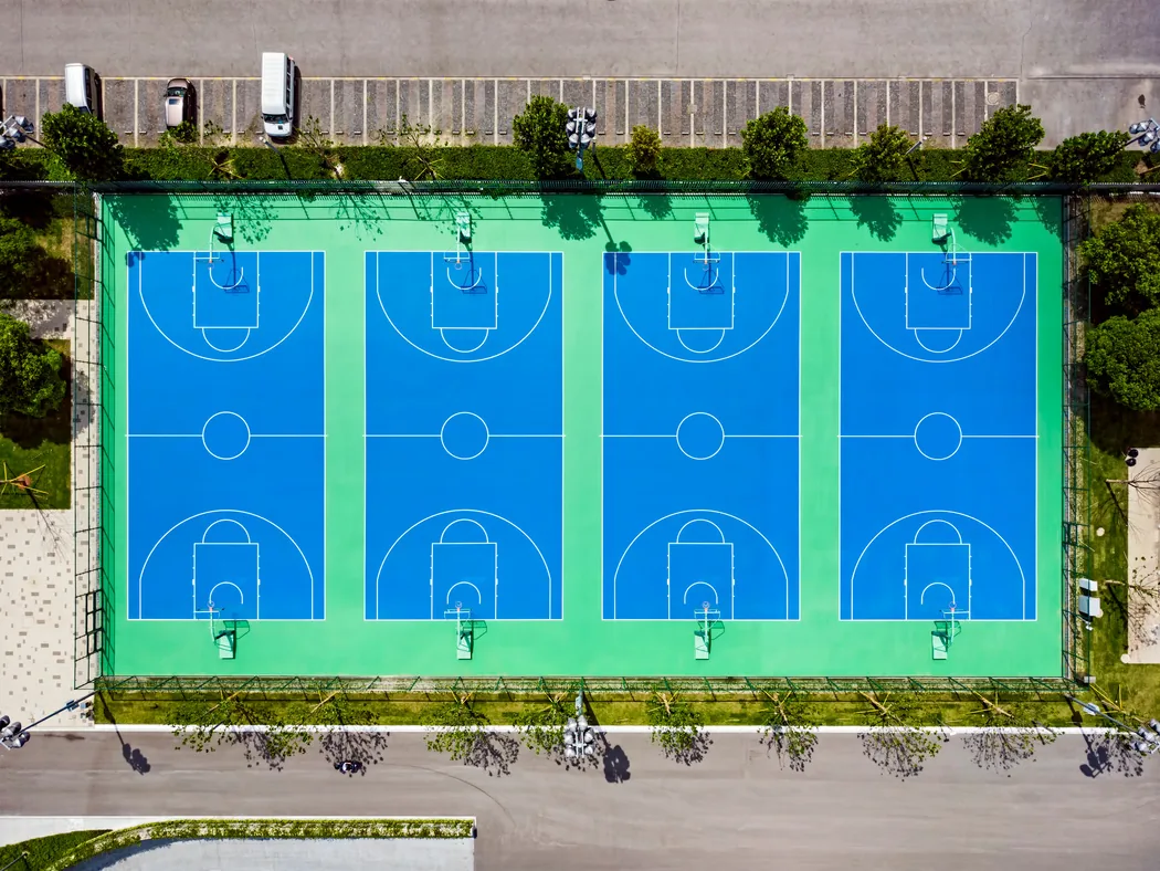 Aerial view of four acrylic basketball courts in blue and green