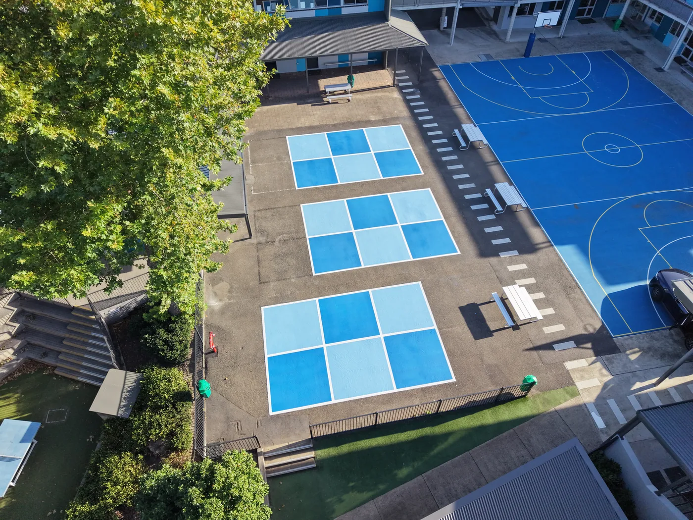 Aerial view of blue handball courts on a school playground