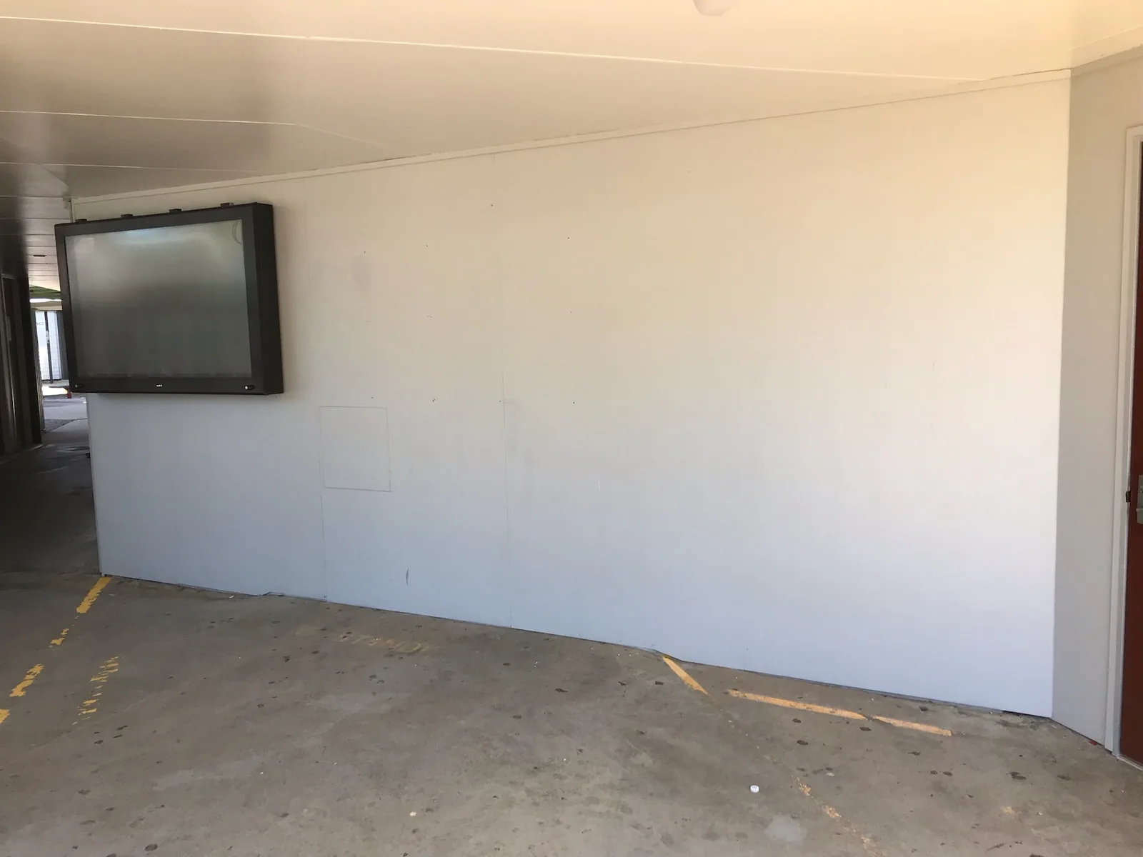 Plain white wall in a school undercover area before a mural