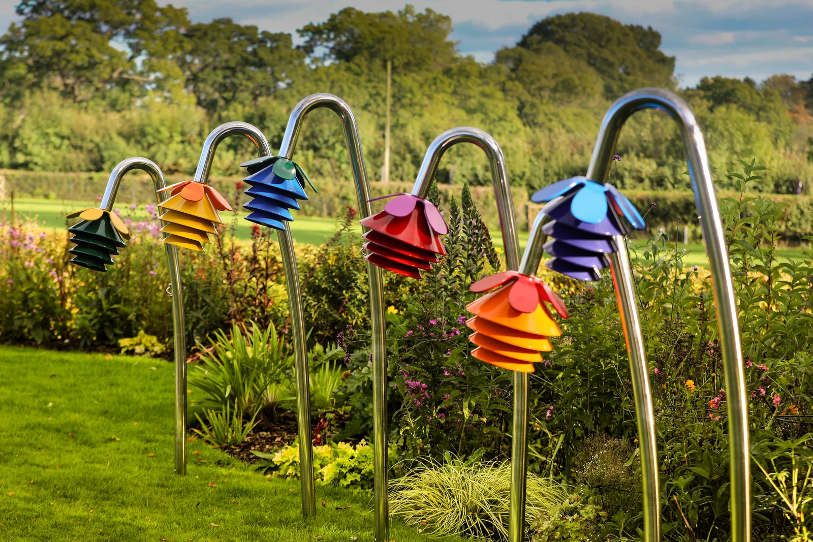 Rainbow coloured Harmony Flowers outdoor chimes in a garden